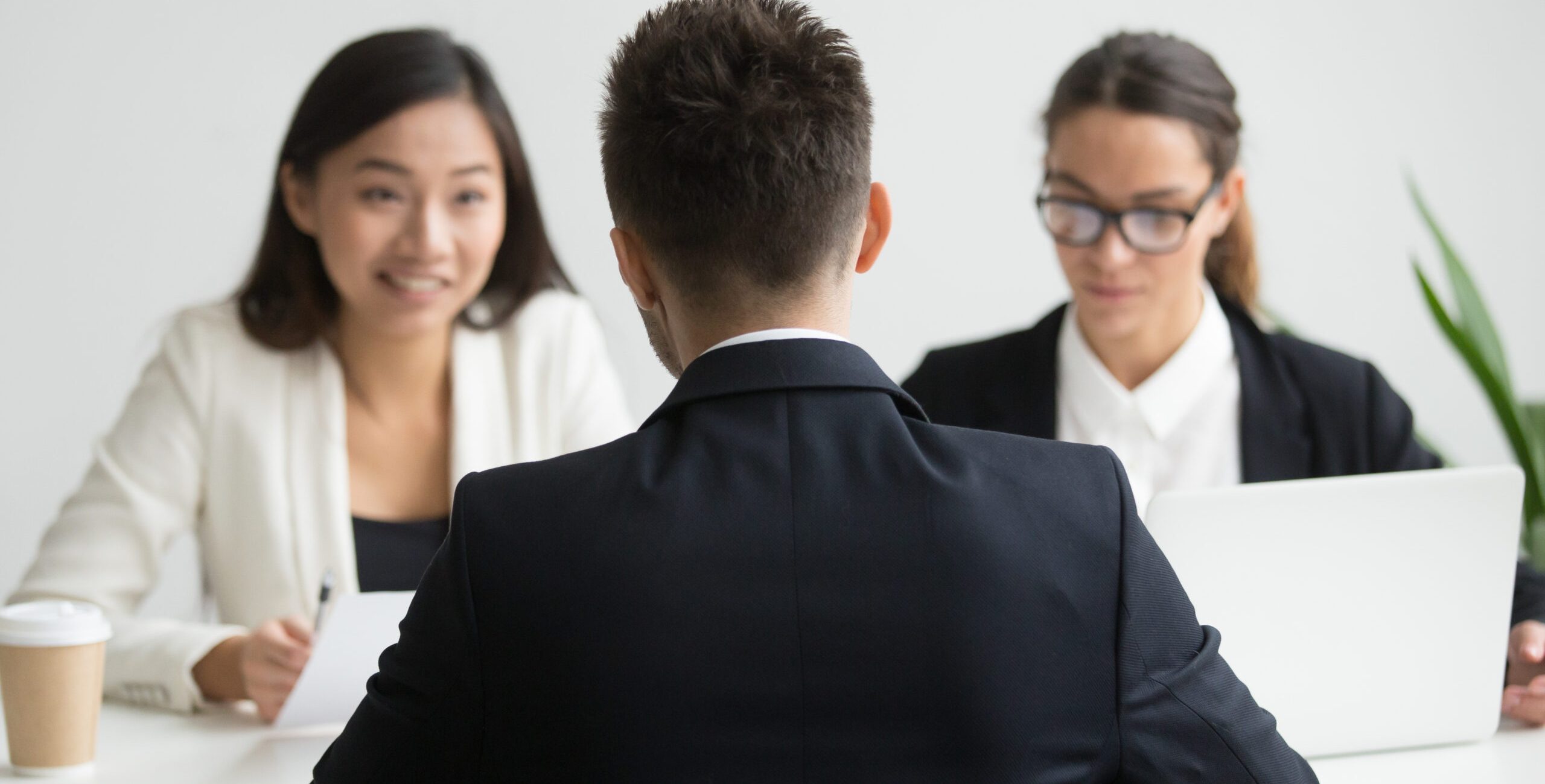 Male job applicant being interviewed by diverse HR representatives team discussing his work experience, sharing thoughts during recruitment process in company office. Concept of hiring, employment