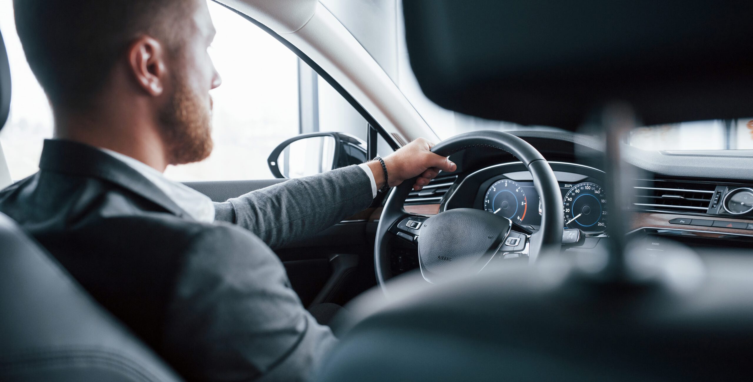 One person. Modern businessman trying his new car in the automobile salon.