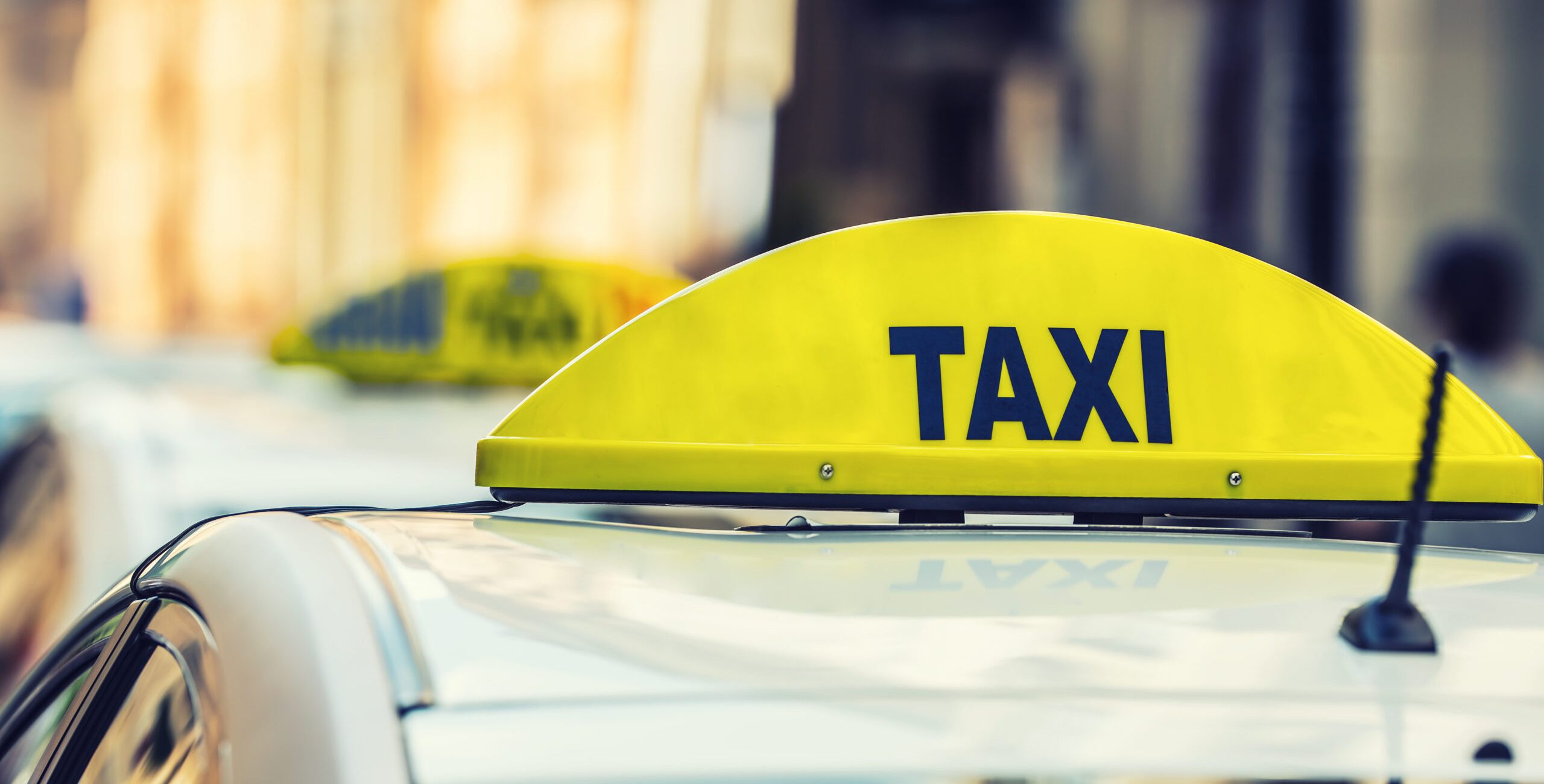 Taxi car waiting passengers in town.Taxi light on the cab of the car ready to transport the passengers.